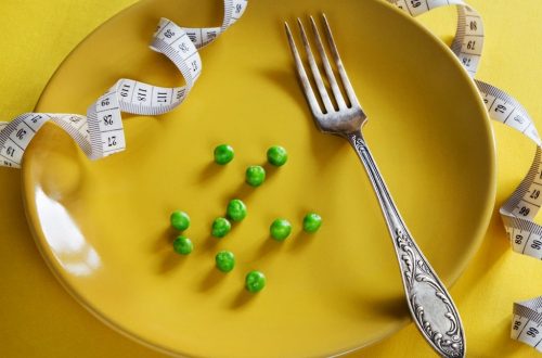 Diet yellow plate with centimeter peas and fork
