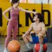 A couple sharing a moment in a gym setting with medicine balls, expressing fitness and togetherness.
